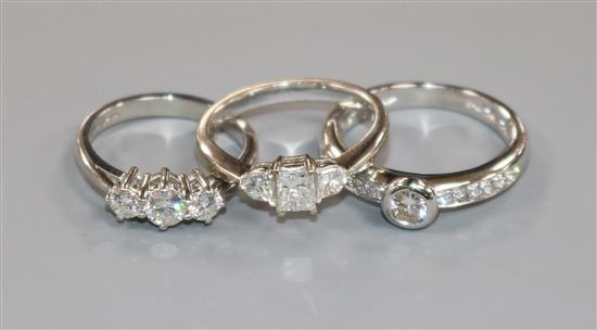 Two 18ct white gold and diamond rings and a platinum and three stone diamond ring.